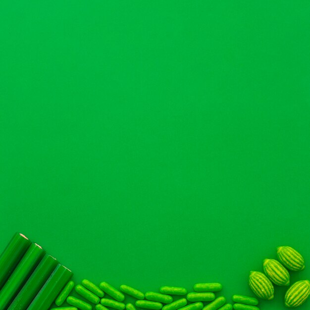 緑色の背景の下にあるさまざまなタイプのキャンディー