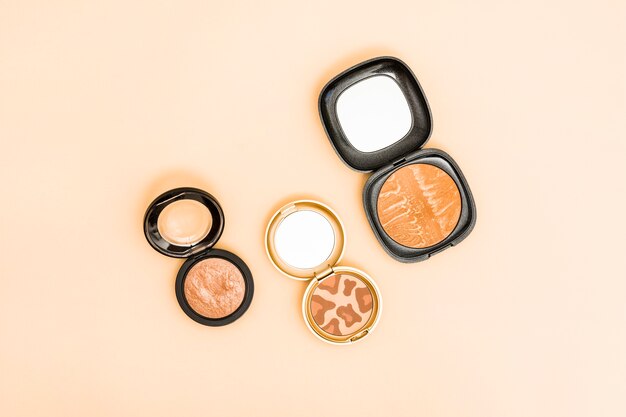 Different type of compact face powder on beige background