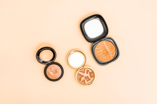 Different type of compact face powder on beige background