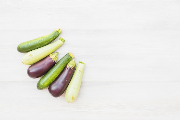 Different type of eggplants on wooden background