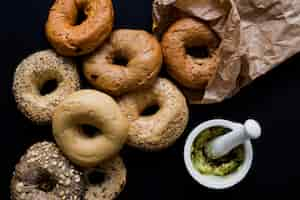 Free photo different type of fresh baked rings with seeds on black backdrop