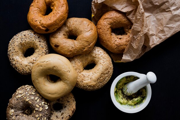 Different type of fresh baked rings with seeds on black backdrop