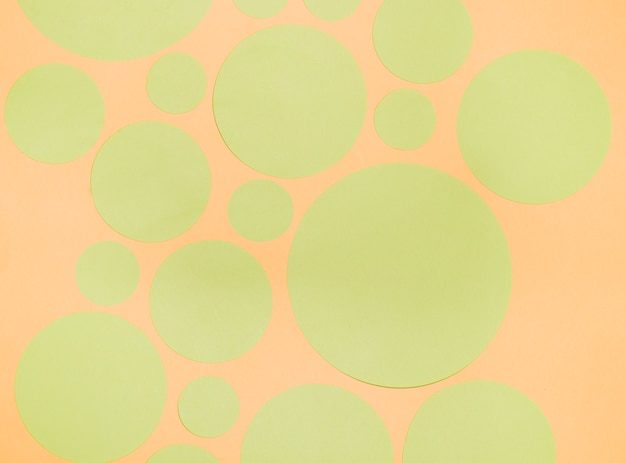 Foto gratuita diversi tipi di cerchi di carta verde su uno sfondo arancione