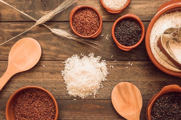 Different type of organic rice grain on wooden table