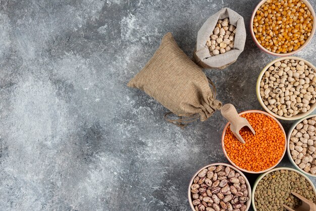 Different type of raw dry legumes composition on marble table surface.