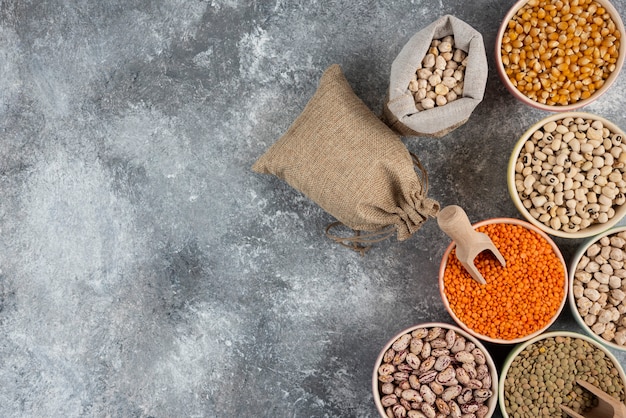 Different type of raw dry legumes composition on marble table surface.