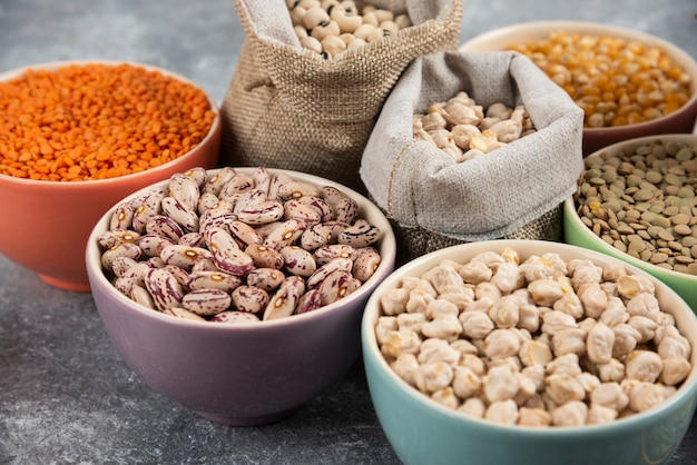 Different type of raw dry legumes composition on marble table surface.