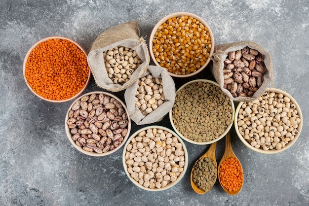 Different type of raw dry legumes composition on marble table surface.