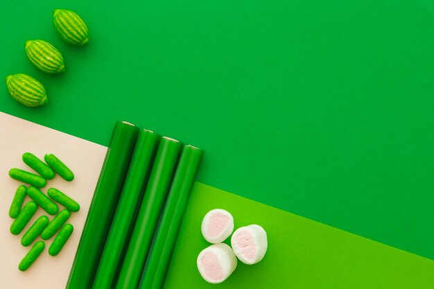 Different type of sweet candies on green background