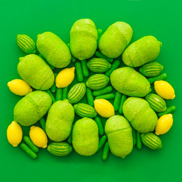 Different type of sweet candies on green background