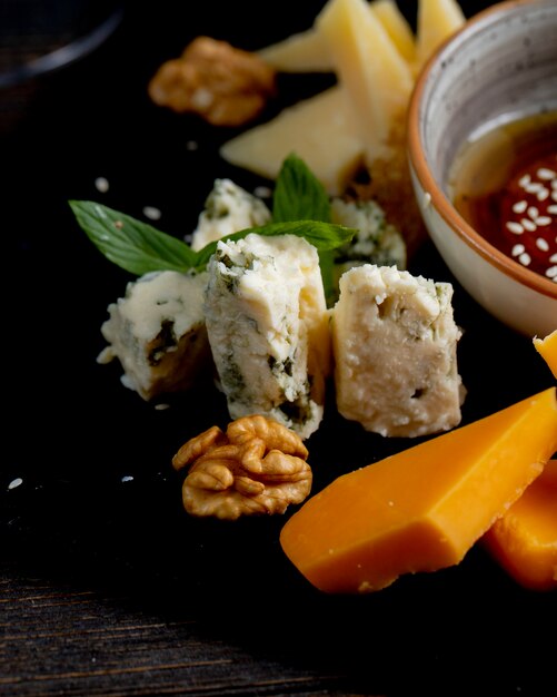 Different types of cheese with walnuts and and sauce