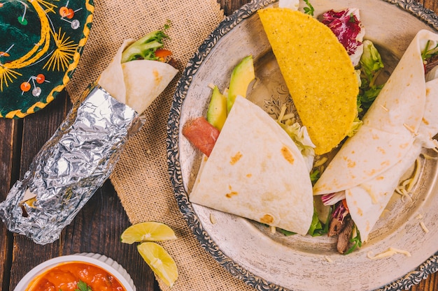 Different types of delicious mexican food in plate with hat