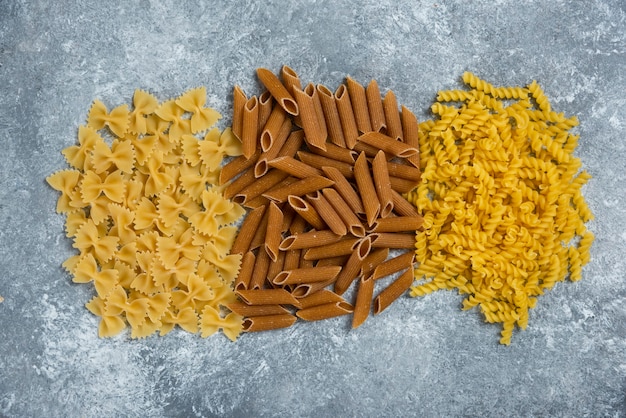 Free photo different types of pasta on gray.