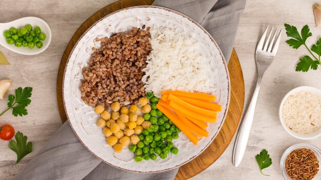 Different types of porridge with cooked vegetables on wooden board 