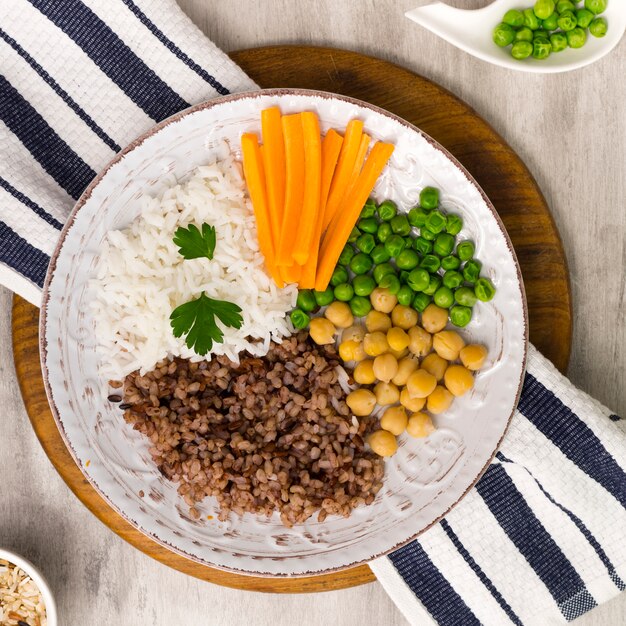 Different types of porridge with vegetables on big wooden board