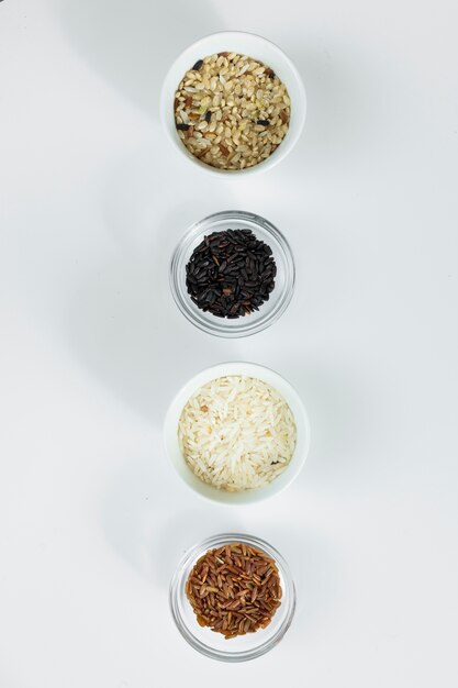 Different types of rice in bowls on table