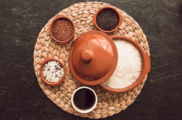 Различные виды чашек с зерном риса с открытым горшком над местом на текстурированном