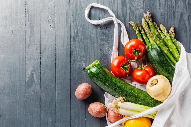 Different vegetables in textile bag on grey copyspace