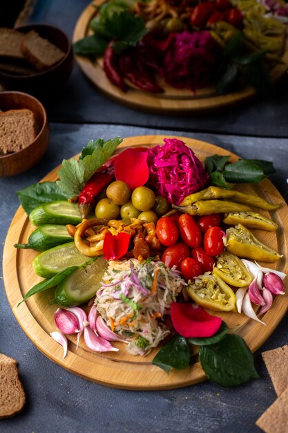 different vegetables tomatoes green pepper olives and other vegetables on brown desk