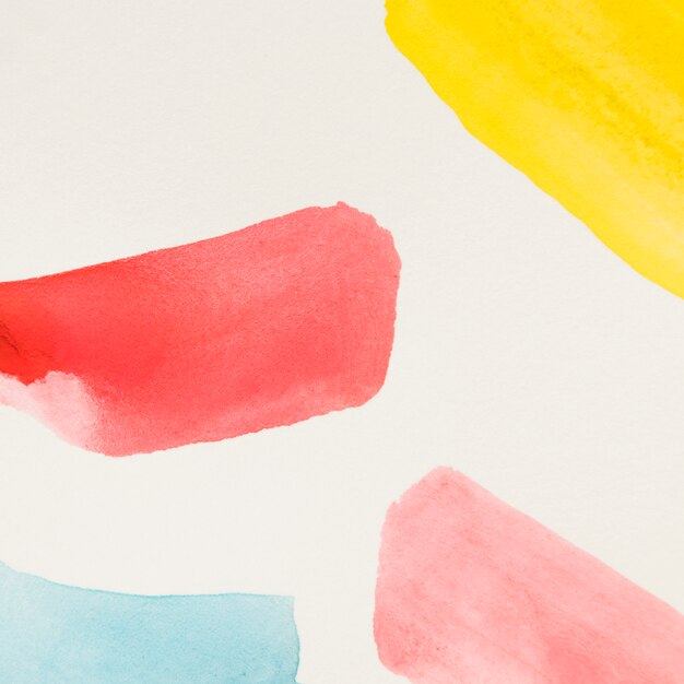 Different yellow; red and blue brush stroke of watercolor on white background