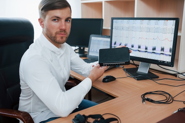 Free photo digital device. polygraph examiner works in the office with his lie detector's equipment