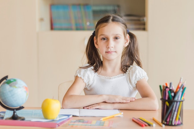 Foto gratuita ragazza diligente seduto alla scrivania