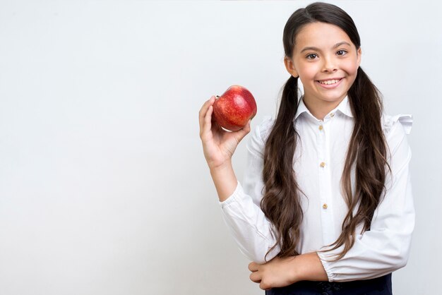 Добросовестная испанская школьница ест яблоко