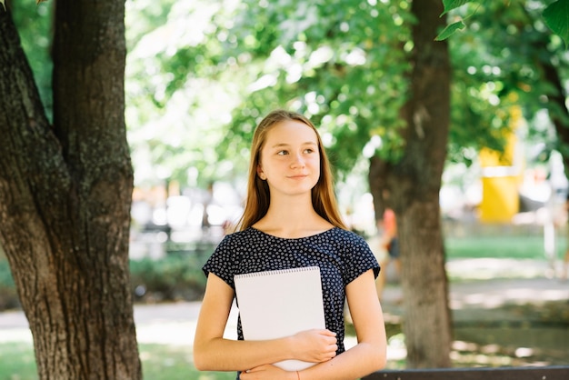 Diligent schoolgirl posing with notepad