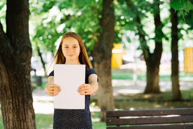 Foto gratuita studente diligente mostrando il blocco note