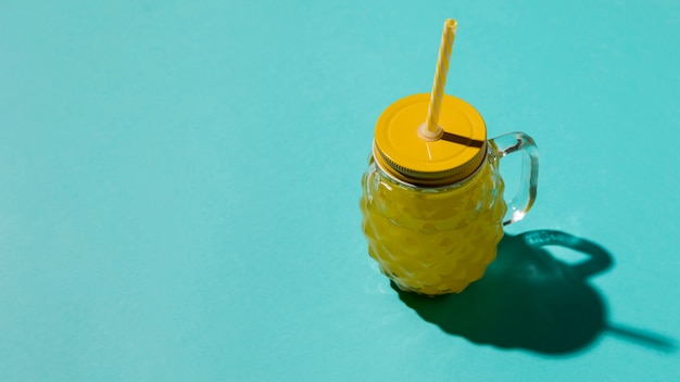 Bicchiere di vetro con coperchio giallo e paglia