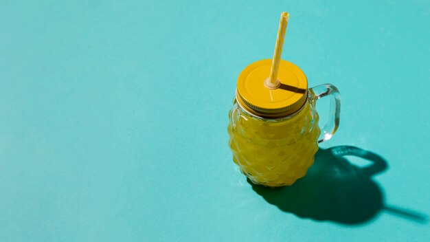 Dimpled glass with yellow lid and straw
