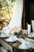 Free photo dining table with floral centerpiece at wedding reception.