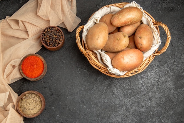 Dinner background with uncooked potatoes with different spices