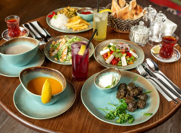 Dinner set with dolma soups, salads and chicken with rice and french fries