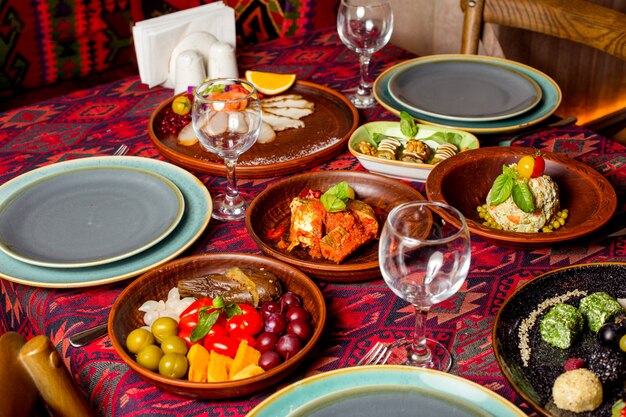 A dinner setup with side dish salad and pickles plates