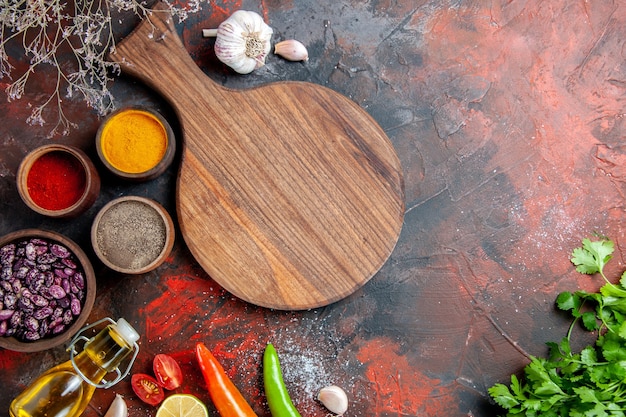 Dinner table fallen oil bottle beans cutting board and different spices