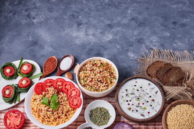 Dinner table with mixed foods in white dishes.