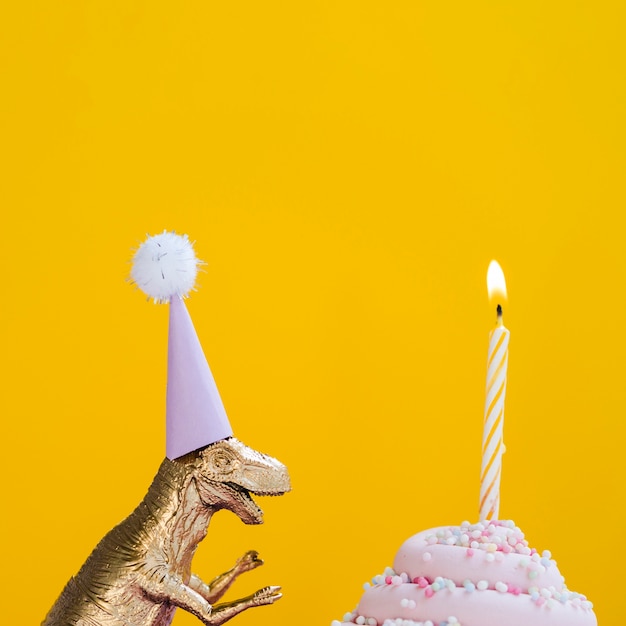 Dinosaur with birthday hat and delicious muffin