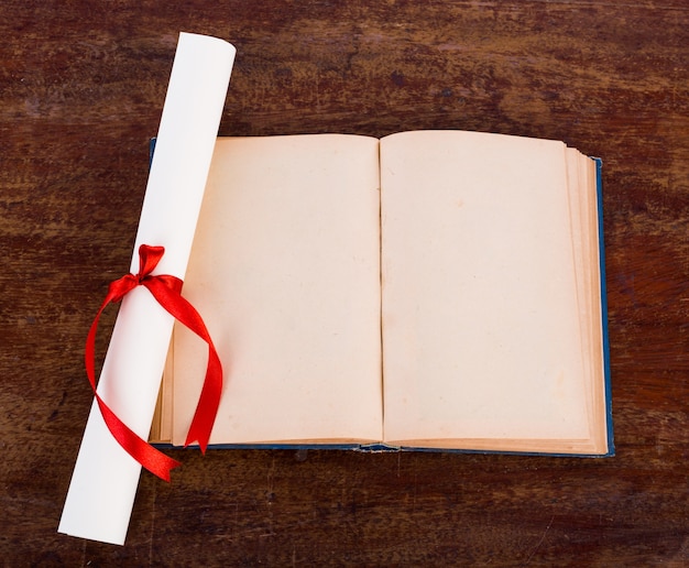 Free photo diploma with old book isolated  on a white background.