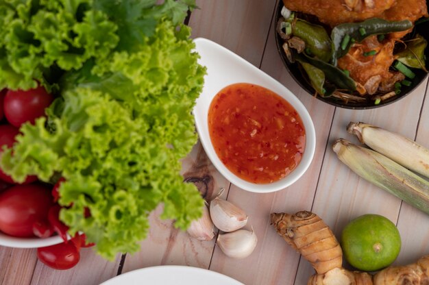 Immersione, citronella, aglio, lime, galanga, pomodoro e insalata sul pavimento di legno