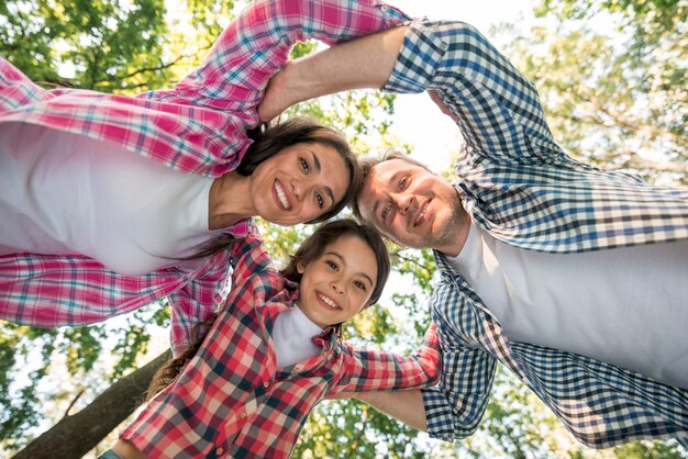 Directly below of happy family forming huddle at park