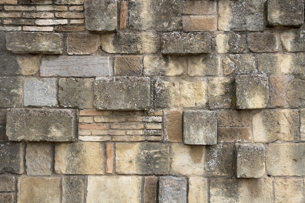 Dirty brick wall with uneven blocks