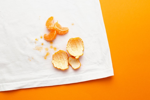Грязные пятна на белой одежде от фруктов мандарина на оранжевом фоне Premium Фотографии