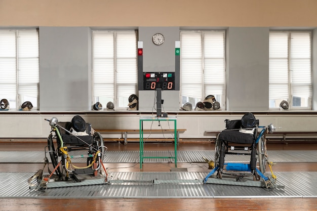 Бесплатное фото Специальная экипировка фехтовальщиков-инвалидов на инвалидных колясках