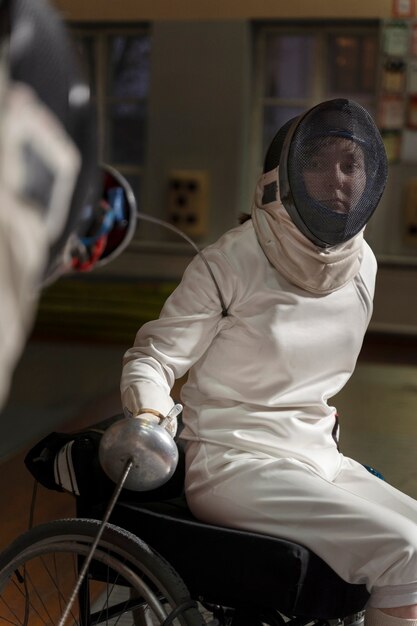 Disabled fencer in special equipment sitting in a wheelchair