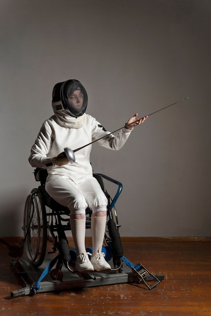 Disabled fencer in special equipment sitting in a wheelchair