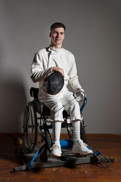 Фехтовальщик-инвалид в специальной экипировке, сидящий в инвалидной коляске