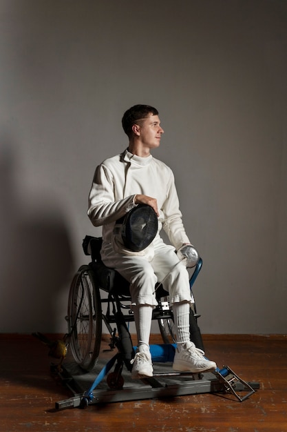 車椅子に座っている特別な機器の障害者フェンシング選手