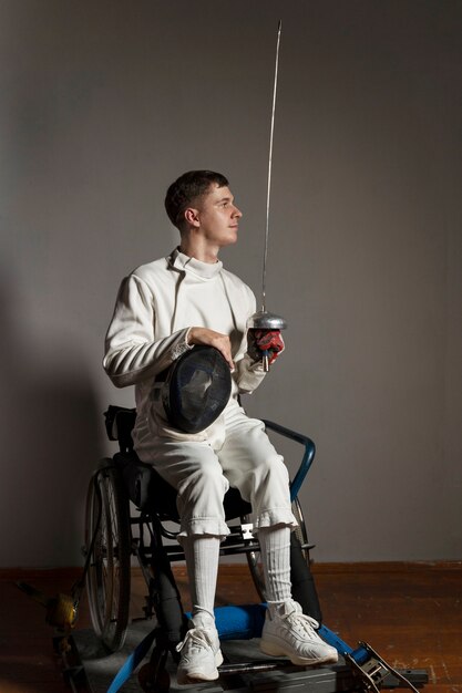 Фехтовальщик-инвалид в специальной экипировке, сидящий в инвалидной коляске