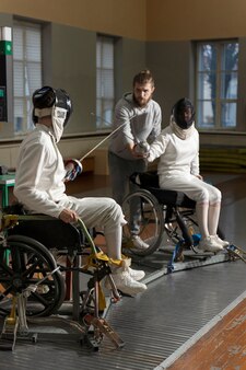 휠체어에서 싸우는 특수 장비의 장애인 펜싱 선수
